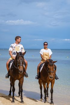 horse riding on the beach, man and woman on horse on the beach during luxury vacation in Mauritius