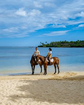 horse riding on the beach, man and woman on horse on the beach during luxury vacation in Mauritius
