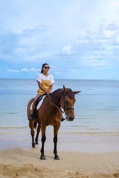 horse riding on the beach, woman on horse on the beach during luxury vacation in Mauritius
