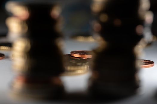 Stacked Euro coins out of focus and in between Copper cent coins in focus