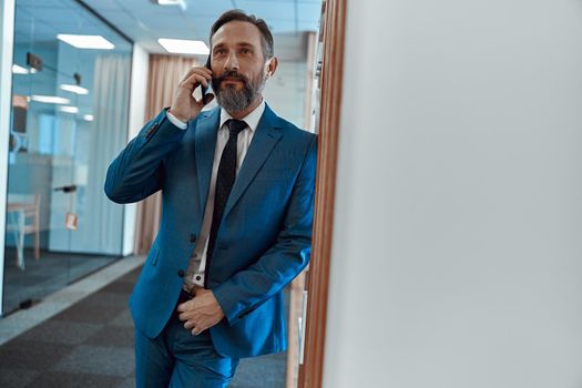Busy man calling on his mobile phone in the office