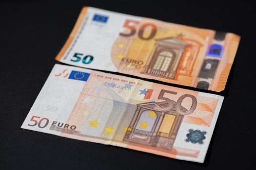 Old and new 50, fifty Euro banknotes on dark background. European monetary Union. Design of Euro cash Banknotes. EU currency Euro