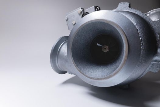 New turbocharger with aluminum cold section. on a gray contrasting background. car engine turbocharger. spare parts