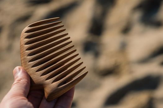 Handmade wooden comb for scalp massage and hair combing. Hair care concept.