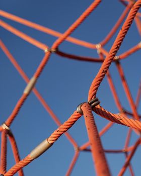 Climbing rope net with blue sky background. Close-up of part of a sports and gaming complex.