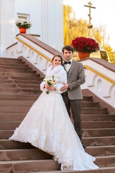Newlyweds on high steps near the Orthodox Church
