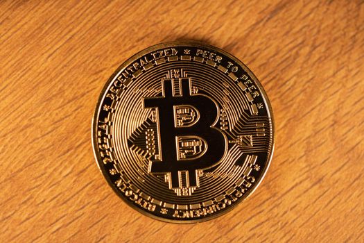Bitcoin on Wooden surface. Gold Coin with BTC Logo. Digital Cryptocurrency. 