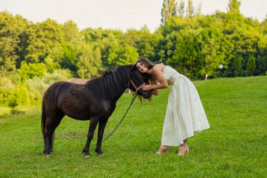 woman petting a pony