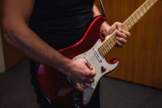 Repetition of a rock band in the studio. Cropped image of an electric guitar player.
