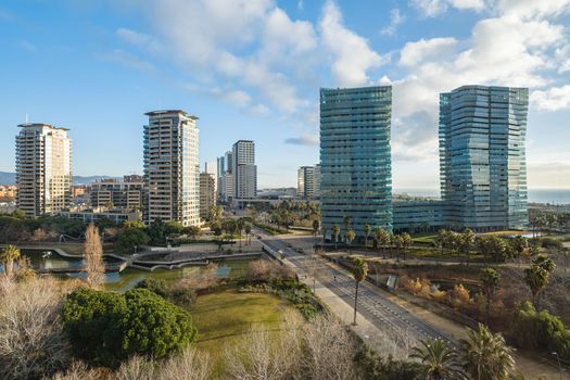 View of expensive area with park and modern high-rise buildings. Diagonal Mar district close to the sea in Barcelona, Spain.