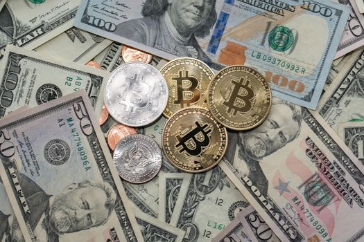 Bitcoin coins on Dollar Banknotes, fifty and hundred Dollar bills. US Currency and BTC Crypto currency