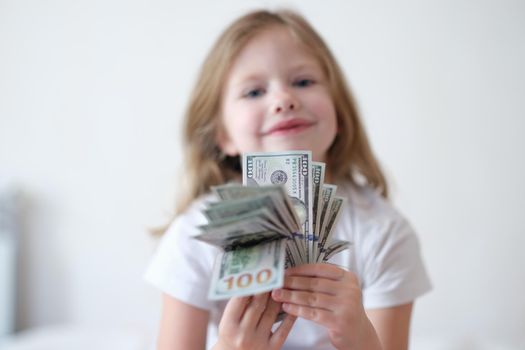 Little smiling girl counting money, happy childhood