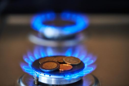 Exploding natural gas prices. Expensive Gas. Euro coins on gas stove