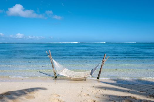 tropical beach with hammock in the ocean, white sandy beach with hammock Le Morne beach Mauritius