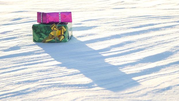 Christmas gifts in a field on snow in a sunny, frosty and clear weather outdoors.