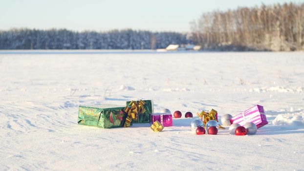 Christmas gifts in a field on snow in a sunny, frosty and clear weather outdoors.