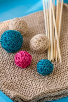 Colorful balls and wooden needles lying on beige