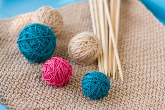 Colorful balls and wooden needles lying on beige 