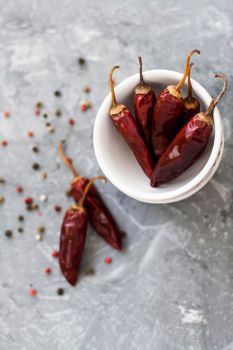 Red sharp dried dried chillies of pepper and pepper in grains on a vintage gray background