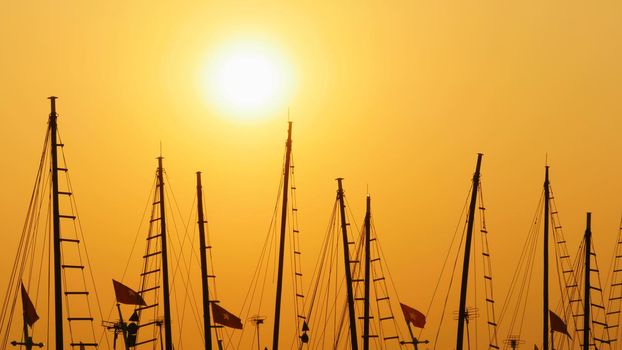 Masts of ships and boats at sunset. Vietnam.