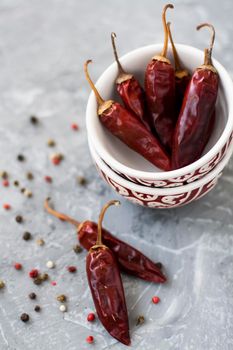 Red sharp dried dried chillies of pepper and pepper in grains on a vintage gray background