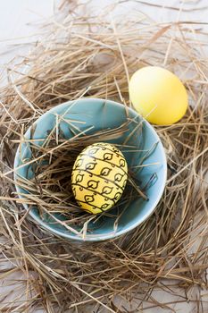 Easter eggs in straw plate on a white background