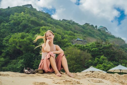 Young woman traveler on amazing Melasti Beach with turquoise water, Bali Island Indonesia