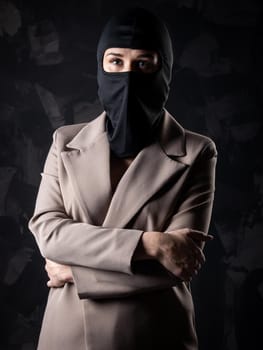 Portrait of a girl in a black balaclava and beige coat.