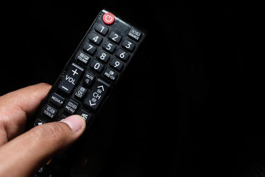close up of man hand holding tv remote.