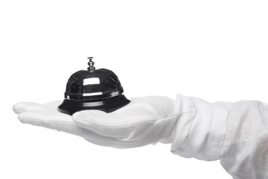 First-class service. Hand in white gloves holding hotel bell
