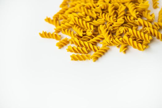 Fusilli pasta close-up on a white plate. Natural pasta made from hard wheat with the addition of pumpkin.