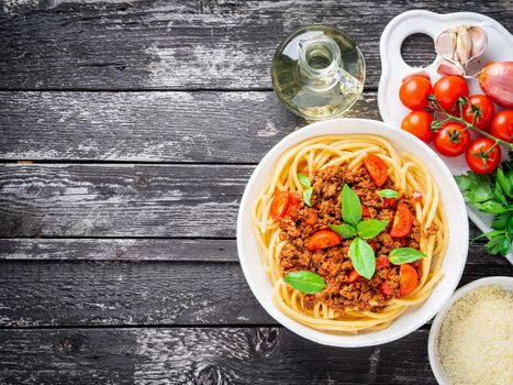 pasta bolognese with tomato sauce, ground minced beef, basil leaves on background