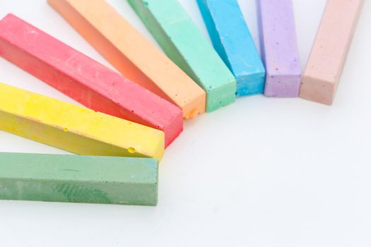 Colored chalks over a white background close up