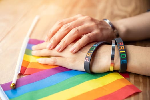 Transgender people hand together with LGBT rainbow flag for sexuality rights campaign symbol
