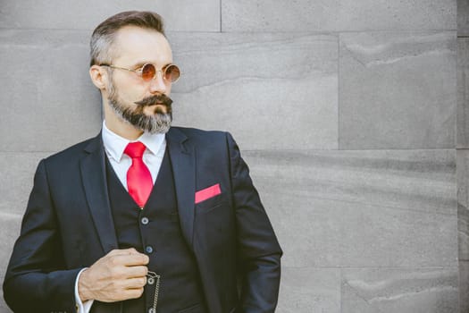 Bearded handsome man Latin model with stylish suit and sunglasses standing portrait