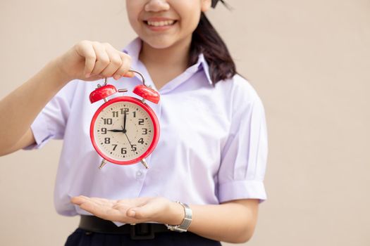 Asian Student handle alarm clock for education times or go to school happy smile.
