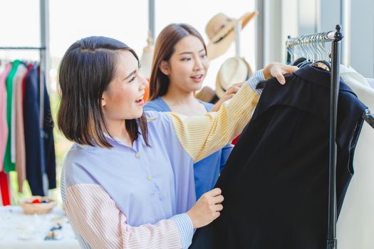 Asian girls teen enjoy shopping to select new cloth with friend in fashion shop like black color cloth.