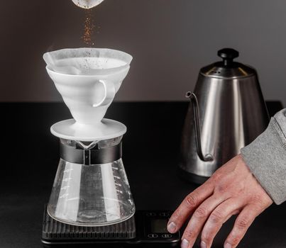 Alternative method of making coffee. coffeemaker is a manual pour-over style glass. Cofee brewing on black background.