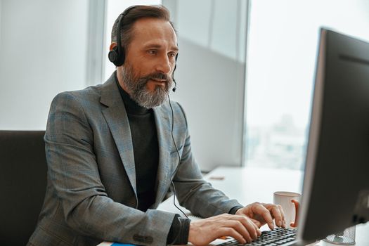 Smiling man is busy while speaking online