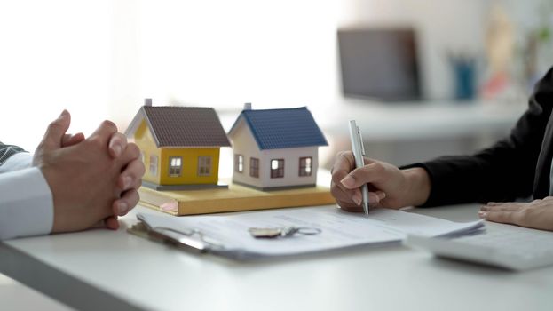 Real estate agent or sales manager has proposed terms and conditions to customers who sign house purchase agreements with insurance, Agreement to sign the purchase contract concept.