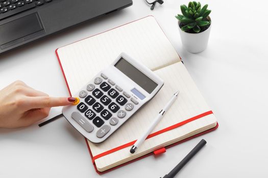 Business woman working with financial data hand using calculator
