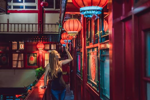 Young woman tourist looks at the Chinese traditional lanterns. Chinese New Year. Travel to China concept