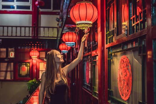 Young woman tourist looks at the Chinese traditional lanterns. Chinese New Year. Travel to China concept