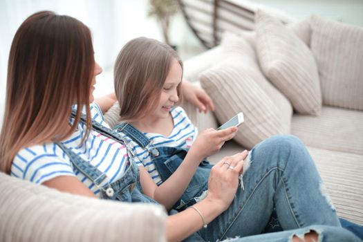 mom and her daughter reading SMS on smartphone