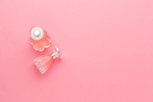 Perfume bottles on pink background. creative photo.