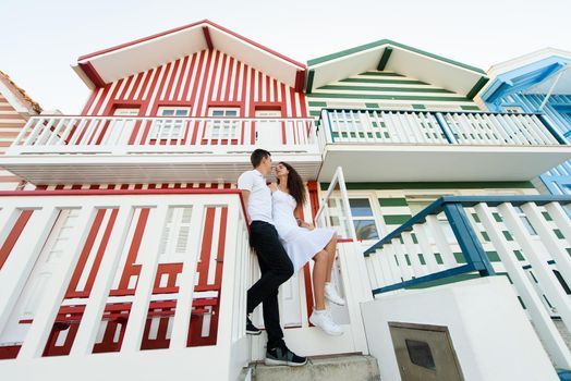 Love story of couple have fun and smiles and looks each others in Aveiro, Portugal near colourful and peaceful houses. Lifestyle.