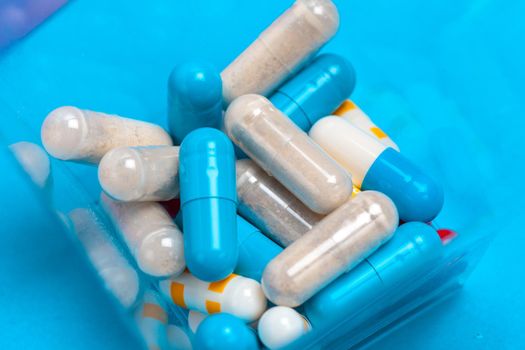 set of multi-colored tablets and capsules on a blue background