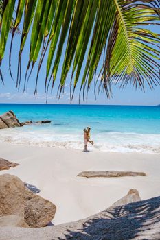 Praslin Seychelles tropical island with withe beaches and palm trees, couple men and women mid age on vacation at the Seychelles visiting the tropical beach of Anse Lazio Praslin Seychelles
