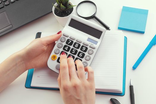 Business woman working with financial data hand using calculator
