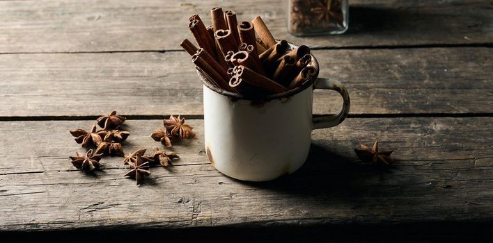 dry brown cinnamon sticks in a metal old mug, culinary spice